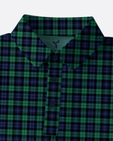 A close-up of a collared button-front shirt with a green and black tartan plaid pattern, shown against a light gray background.