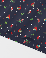 A close-up of navy blue fabric with a festive Christmas print featuring Santa Claus, elves, gift boxes, candy canes, and green trees, with white polka dots, shown against a white background.