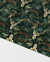 A close-up of a forest-themed patterned surface featuring repeated deer heads with antlers, pinecones, evergreen branches, and small wildflowers on a dark green background. A large light gray rectangular area overlays the lower-left portion of the image.